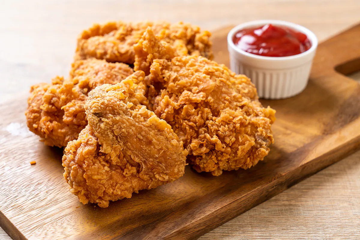 Golden fried chicken pieces served with a side of dipping sauce