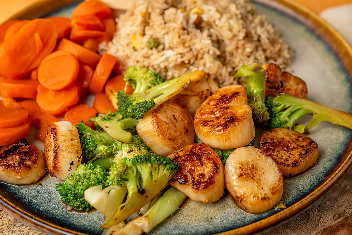 Seared scallops with broccoli carrots and fried rice